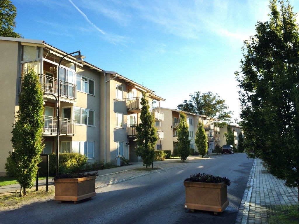 Fasaden på huset med gruppbostad. Byggnad i tre våningar vid trädkantad väg.