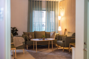 Samlingsrum med nätt, grå soffgrupp.