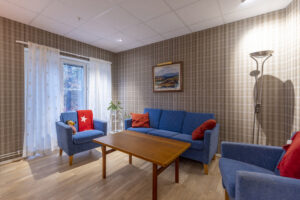 Samlingsrum med blå soffgrupp.