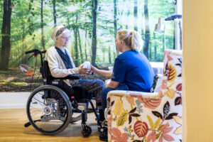 Medarbetare och boende håller hand och samtalar.